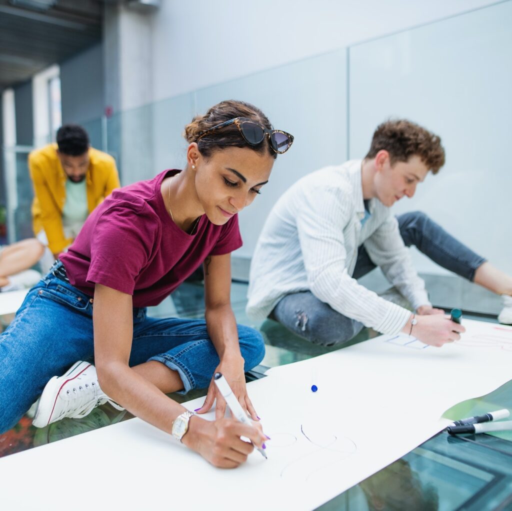 Students activists making banners for protest indoors, fighting for free education concept.